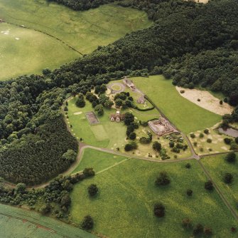 Oblique aerial view of Dunglass centred on the Collegiate Church with Dunglass House stables adjacent, taken from the NNW.