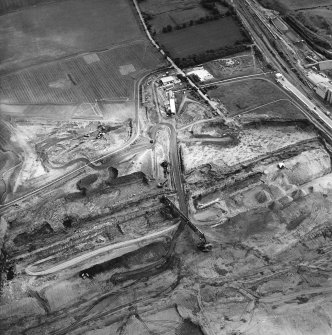 Oblique aerial view centred on the cement works and quarry with the trial excavations adjacent, taken from the NW.