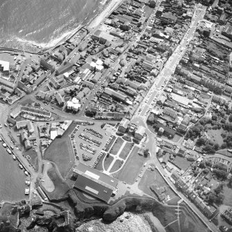 Oblique aerial view centred on the barracks with fishermen's housing at Victoria Place and leisure centre adjacent, taken from the NW.