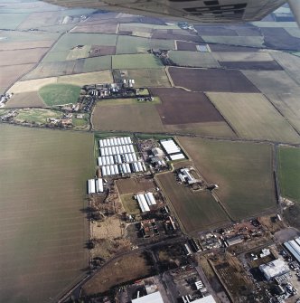 Oblique aerial view centred on the farm, buildings, farmhouse and mushroom farm with farmhouse and buildings adjacent, taken from the W.