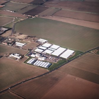Oblique aerial view centred on the farm, buildings, farmhouse and mushroom farm, taken from the SE.