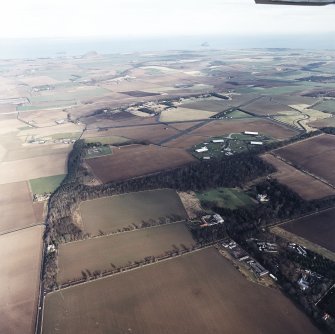 General oblique aerial view looking across the country house, farmstead, airfield and museum towards North Berwick Law and the Bass Rock, taken from the SSW.