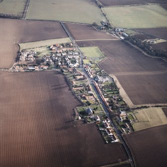 General oblique aerial view centred on the village with the building and farmsteading adjacent, taken from the WNW.