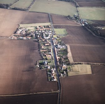 General oblique aerial view centred on the village with the building and farmsteading adjacent, taken from the W.