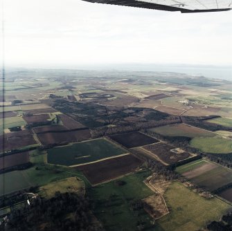 General oblique aerial view looking across Binning Wood towards North Berwick Law and the Firth of Forth, taken from the E.