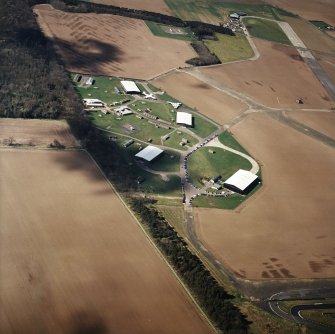 Oblique aerial view of East Fortune Airfield centred on the aircraft hangers, taken from the ENE.