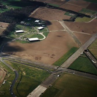 Oblique aerial view of East Fortune Airfield centred on the aircraft hangers, taken from the ENE.