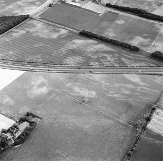 Monkton House and Newton, oblique aerial view, taken from the WNW, centred on a series of cropmarks including those of a pit-alignment. Monkton House is visible in the bottom left-hand corner of the photograph.