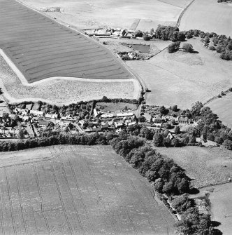 Oblique aerial view centred on the village with country house, farmsteading and stable adjacent, taken from the SSE.