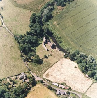 Oblique aerial view centred on the remains of the castle and garden with cottage and smithy adjacent, taken from the E.