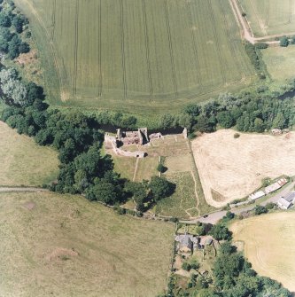 Oblique aerial view centred on the remains of the castle and garden with cottage and smithy adjacent, taken from the SSE.