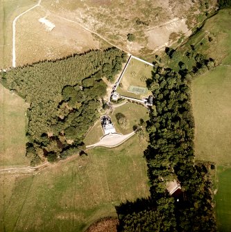 Oblique aerial view centred on the country house, cottage and walled garden, taken from the W.