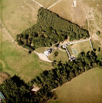 Oblique aerial view centred on the country house, cottage and walled garden, taken from the SW.