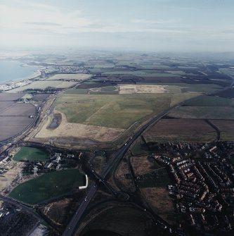 General oblique aerial view looking across the school, town and restored agricultural land towards Longniddry and North Berwick Law, taken from the WSW.