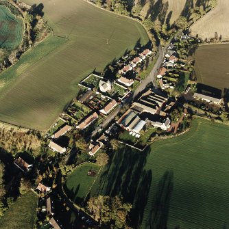 Oblique aerial view of Carrington, General centred on the burgh:village with an adjacent church, taken from the SW.