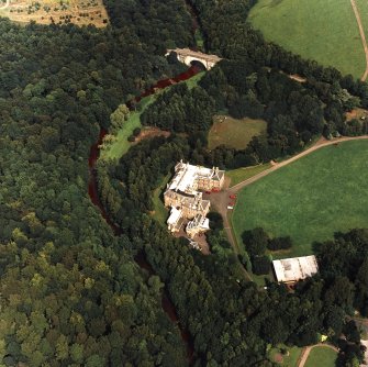 Oblique aerial view centred on the country house and garden with bridge adjacent, taken from the SSW.