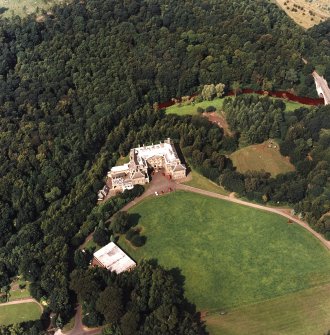 Oblique aerial view centred on the country house and garden with bridge adjacent, taken from the SE.