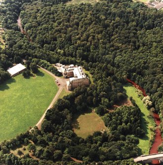 Oblique aerial view centred on the country house and garden with bridge adjacent, taken from the NE.