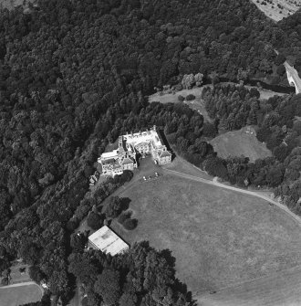 Oblique aerial view centred on the country house and garden with bridge adjacent, taken from the SE.