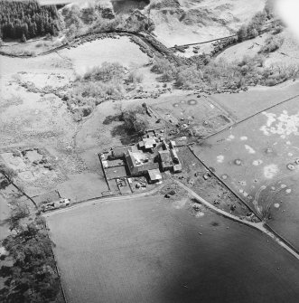 Oblique aerial view centred on the remains of the castle with the remains of the fish ponds, farmhouse and farmsteading adjacent, taken from the NNW.