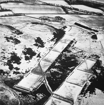 Oblique aerial view centred on the rifle range with the farmhouse and farmsteading and the remains of the fort, trenches and rig adjacent, taken from the NW.