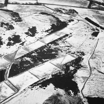 Oblique aerial view centred on the rifle range with the farmhouse and farmsteading and the remains of the fort, trenches and rig adjacent, taken from the WNW.