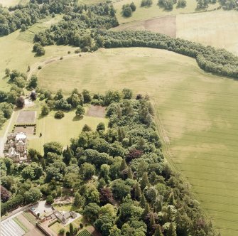 Oxenfoord Castle: oblique aerial view, taken from the NW, centred on cropmarks of a possible formal garden and linear cropmarks. Oxenfoord Castle is also visible in the left centre of the photograph.