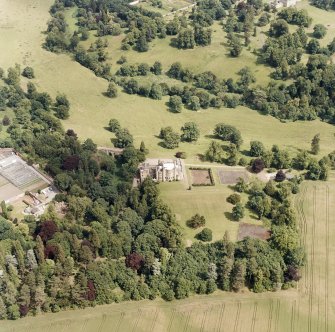 Oblique aerial view, taken from the SW, centred on Oxenfoord Castle.  Preston Hall is also visible in the top right hand corner of the photograph.