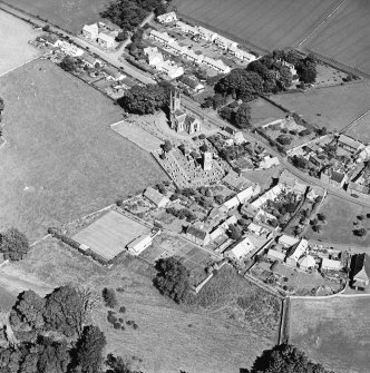 Oblique aerial view centred on the church, burial ground, old church, mausoleum and village, taken from the WNW.