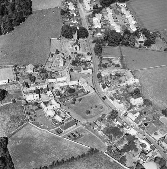 Oblique aerial view centred on the church, burial ground, old church, mausoleum and village, taken from the SW.