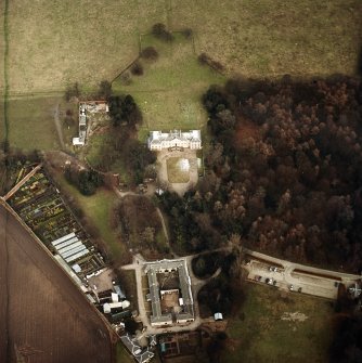 Oblique aerial view centred on the country house with walled garden, stables, cottage, formal garden, gate lodge and dovecot adjacent, taken from the SW.
