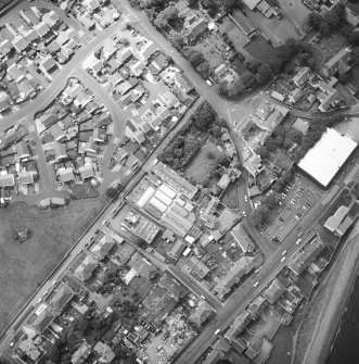 Oblique aerial view centred on the house and stables with the church adjacent, taken from the NNE.