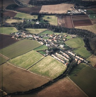 Oblique aerial view centred village with country house and walled garden adjacent, taken from the E.