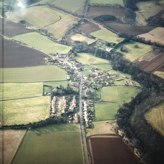 Oblique aerial view centred village with country house and walled garden adjacent, taken from the ENE.