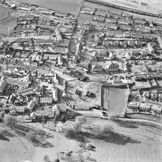 Oblique aerial view centred on the remains of the burial enclosures and village, taken from the SSE.