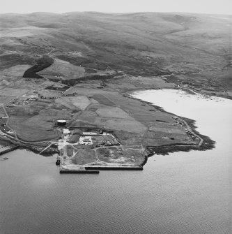Hoy, Lyness, oblique aerial view, taken from the E, centred on the Royal Navy Oil Terminal. Visible in the top left hand corner of the photograph is Wee Fea Naval Signal Station.