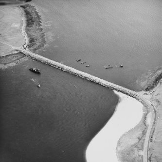 Oblique aerial view from NE, centred on the barrier and the wrecks of the blockships Reginald, Empire Seaman and Martis.
