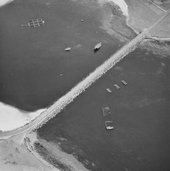 Oblique aerial view from NW, centred on the barrier and the wrecks of the blockships Reginald, Empire Seaman and Martis.