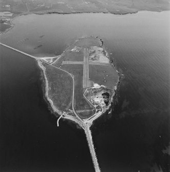 Aerial view, Orkney, Lamb Holm taken from the SW.  Visible is the modern grass landing strip, Lamb Holm World War II coast battery, the concrete hut bases of the former prisoner-of-war camp, the Italian Chapel and parts of Churchill Barriers Nos. 1 and 2.