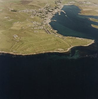 Oblique aerial view of the Second World War Ness and Links Batteries with the First World War Ness Battery situated on the golf course,  taken from the SW.  Also visible in the background is Stromness town and harbour.