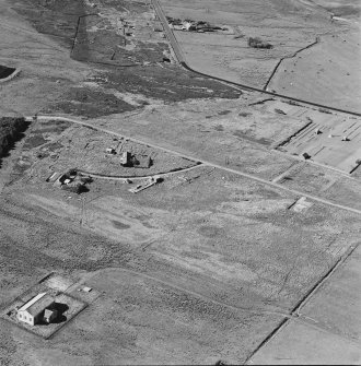 Oblique aerial view of Orkney, Hoy, Lyness, Royal Naval Oil terminal, view from S, of the Pumphouse for the underground oil tanks.  Part of the Naval Cemetery is visible in the background.