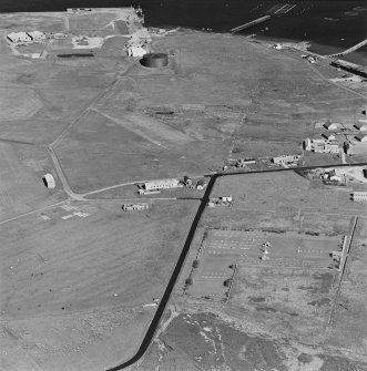 Oblique aerial view of Orkney, Hoy, Lyness, Royal Naval Oil Terminal, view of the Naval Cemetery and a pillbox.  Also visible are are some of the ancillary buildings and the remaining oil tank, museum complex in the N part of the Naval Base.