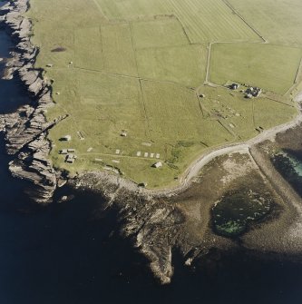 Oblique aerial view of Orkney, Rerwick Head, Rerwick Battery, taken from the N.  Visible are the gun-emplacements, battery observation tower, searchlight platforms, concrete hut bases for the accommodation camp and two air-raid shelters cut into the shore..