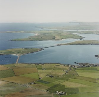 Oblique aerial view from N.  Visible are the Islands of Lamb Holm, Glimps Holm and Burray.  Part of the village of St Mary's is also visible.