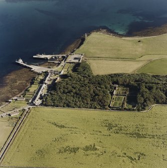 Oblique aerial view of Orkney, Shapinsay, Balfour Castle walled garden, Balfour village and harbour, taken from the N.  The Dishan Tower dovecot is visible in the backghround.