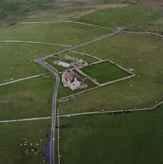 Oblique aerial view centred on the remains of the farmhouse, farmsteading and walled garden, taken from the W