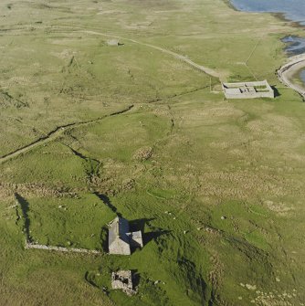 Oblique aerial view of the croft buildings, pound and remains of the enclosures with the remains of the building and enclosure adjacent, taken from the SW