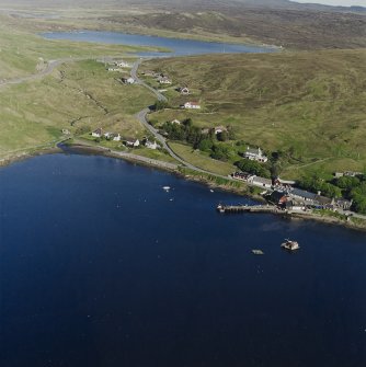 Oblique aerial view looking across Olna Firth to the village of Voe, the fish processing plant and the pier, taken from the WNW.