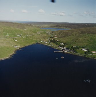 General oblique aerial view looking across Olna Firth to the village of Voe, the fish processing plant and the pier, taken from the W.