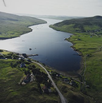 General oblique aerial view looking across Olna Firth to the village of Voe, the fish processing plant and the pier, taken from the E.